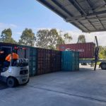 Shipping container truck operating at a logistics depot