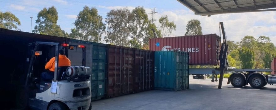 Shipping container truck operating at a logistics depot