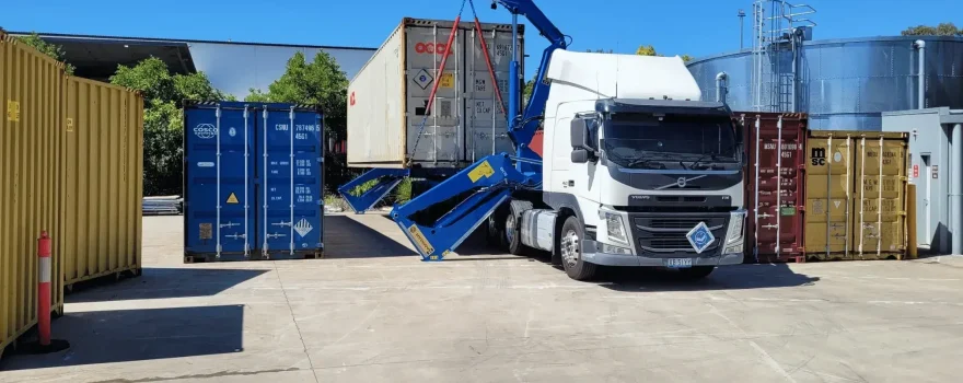 Truck loading a shipping container at a 3PL warehouse with container handling equipment and storage units