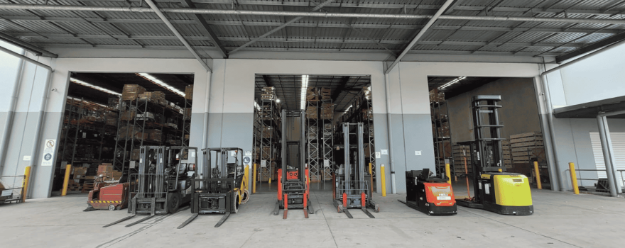 TLC Enterprise warehouse floor with forklifts and material handling equipment supporting warehouse operations